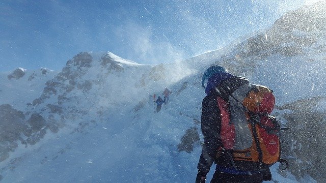 雪の中を登山する人