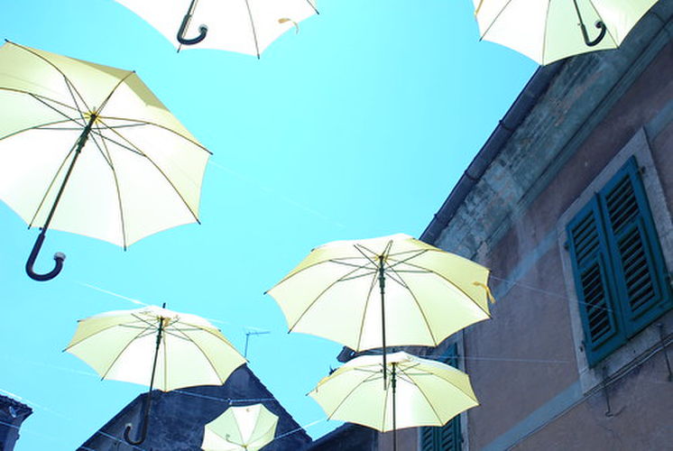 空に浮かび上がる白い傘