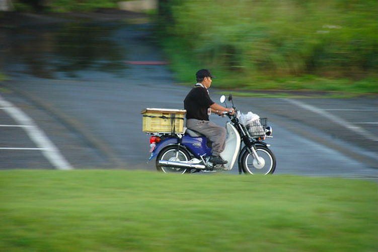 バイクに乗って移動する男性