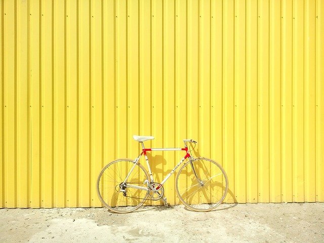 黄色い壁に立てかけられた自転車