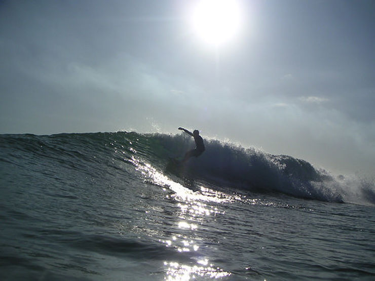 太陽の元でサーフィンをする人