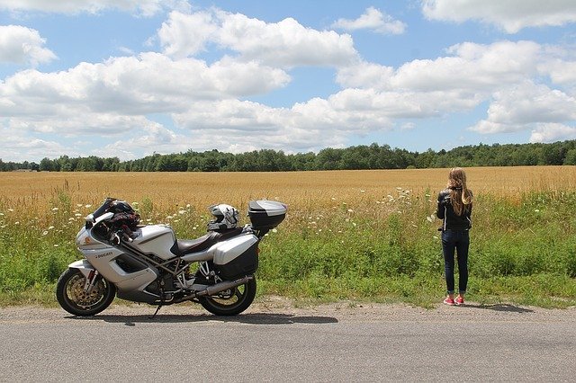景色を眺める女性とバイク
