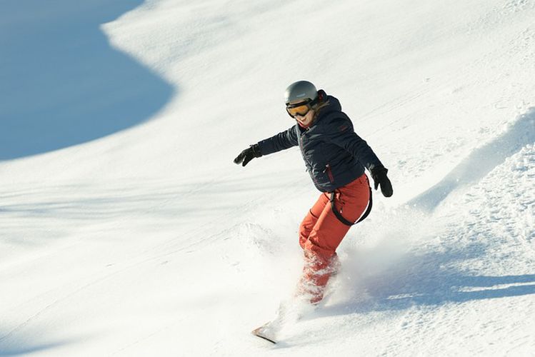 スノーボードで滑る女性